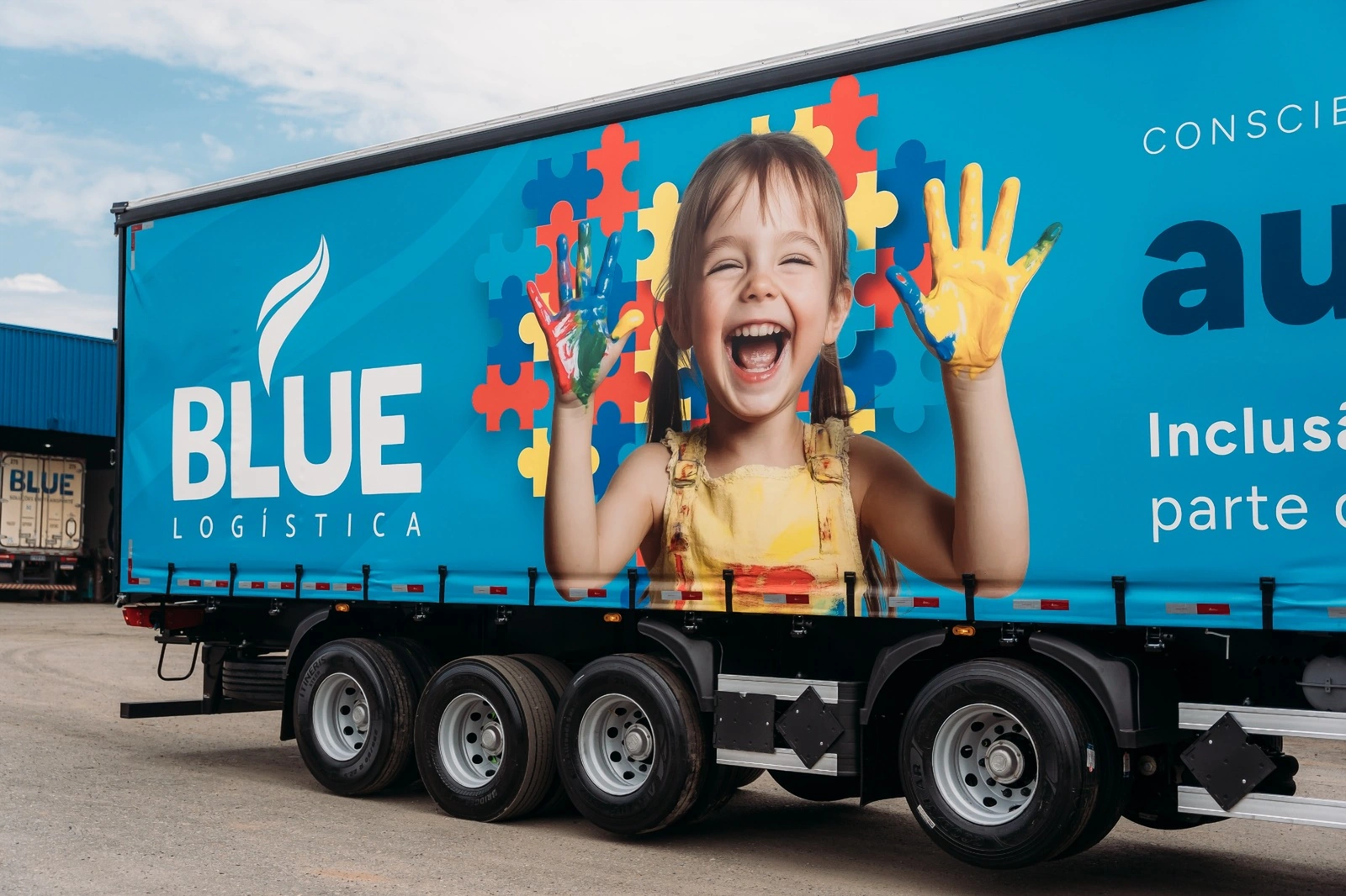 Detalhe da lona da campanha do autismo com a marca BLUE Logística.